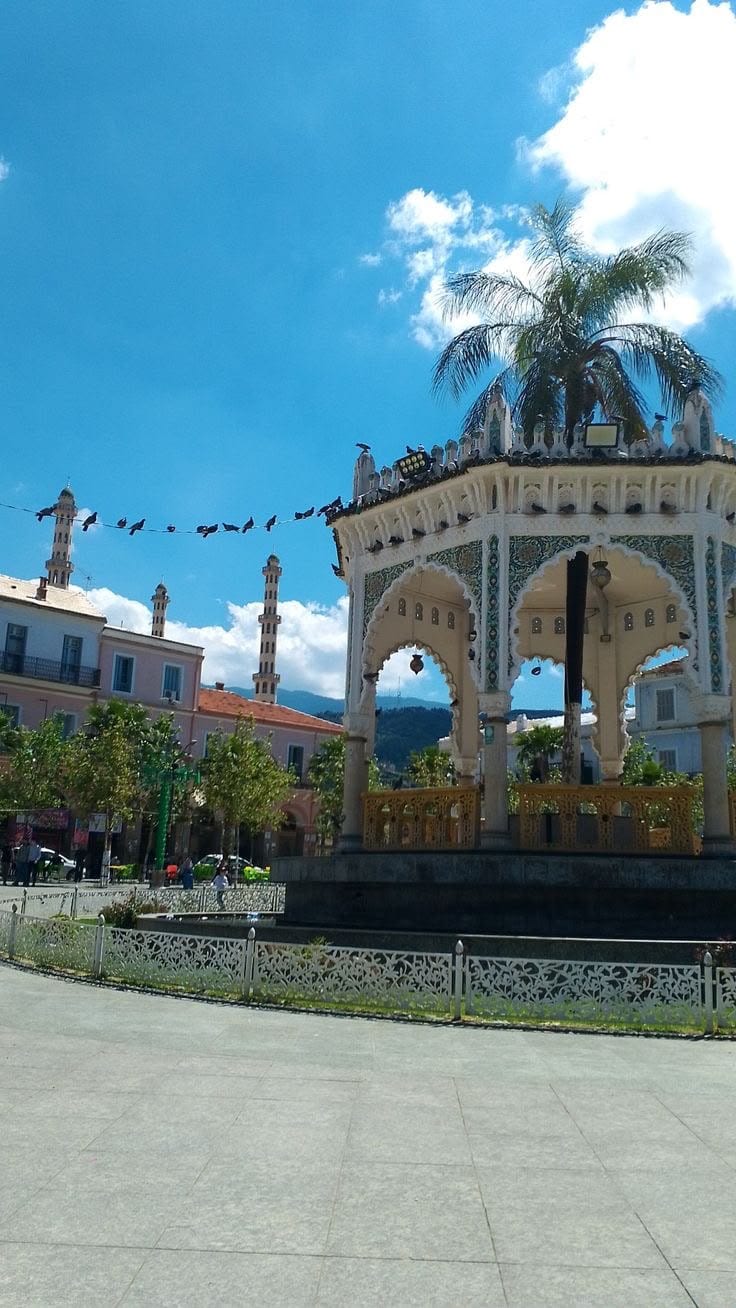 The white Moorish kiosk on the Place d'Armes of Blida, the mountains behind