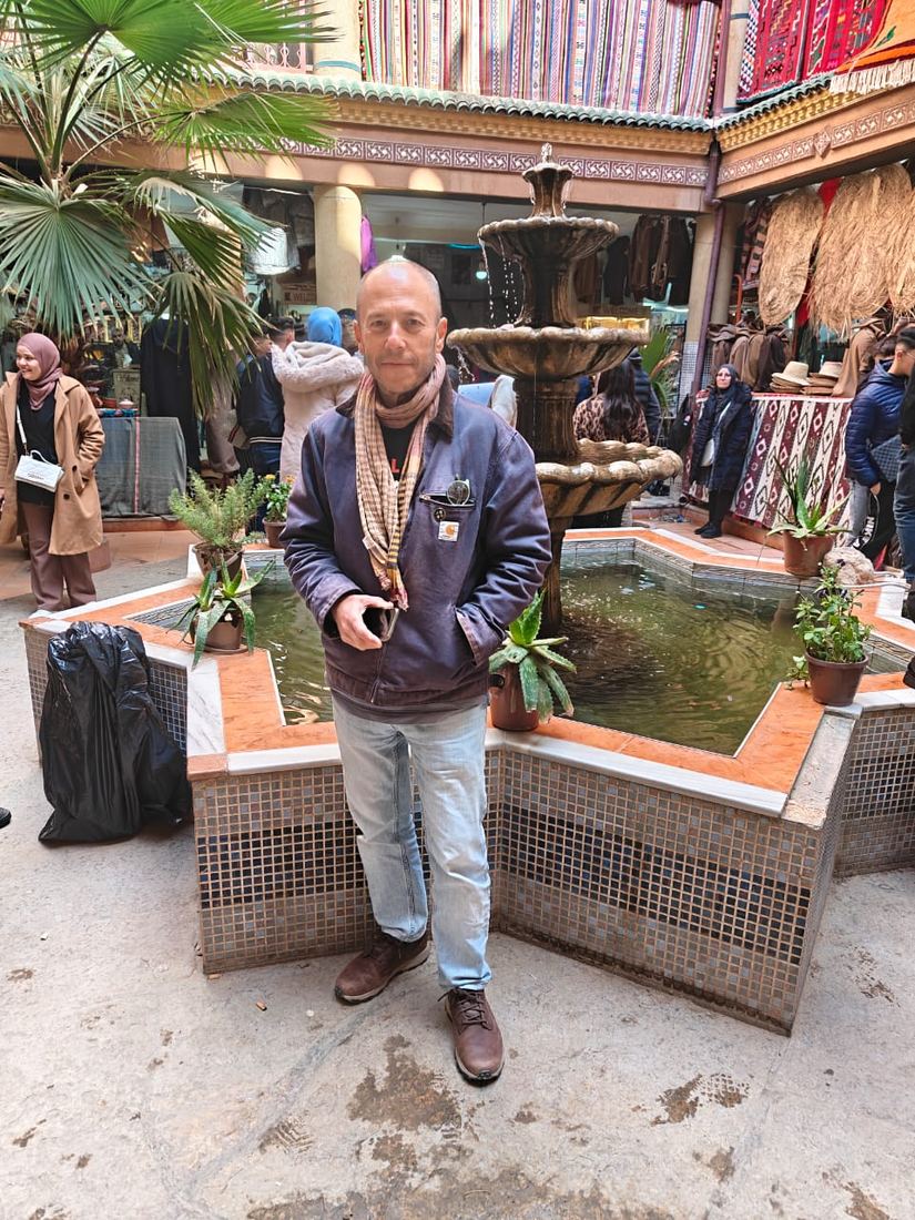 A traveller beside a tiled fountain in the courtyard of a crafts market