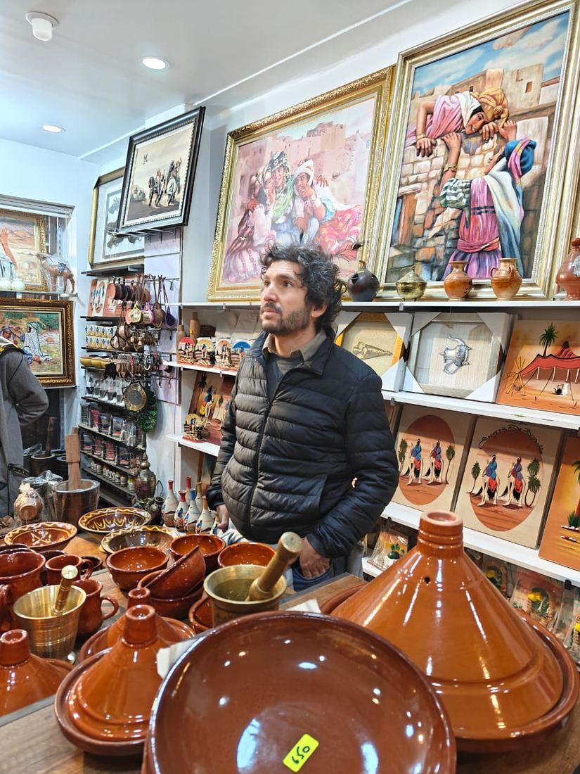 A traveller browsing painted pottery and tagines in a crafts shop