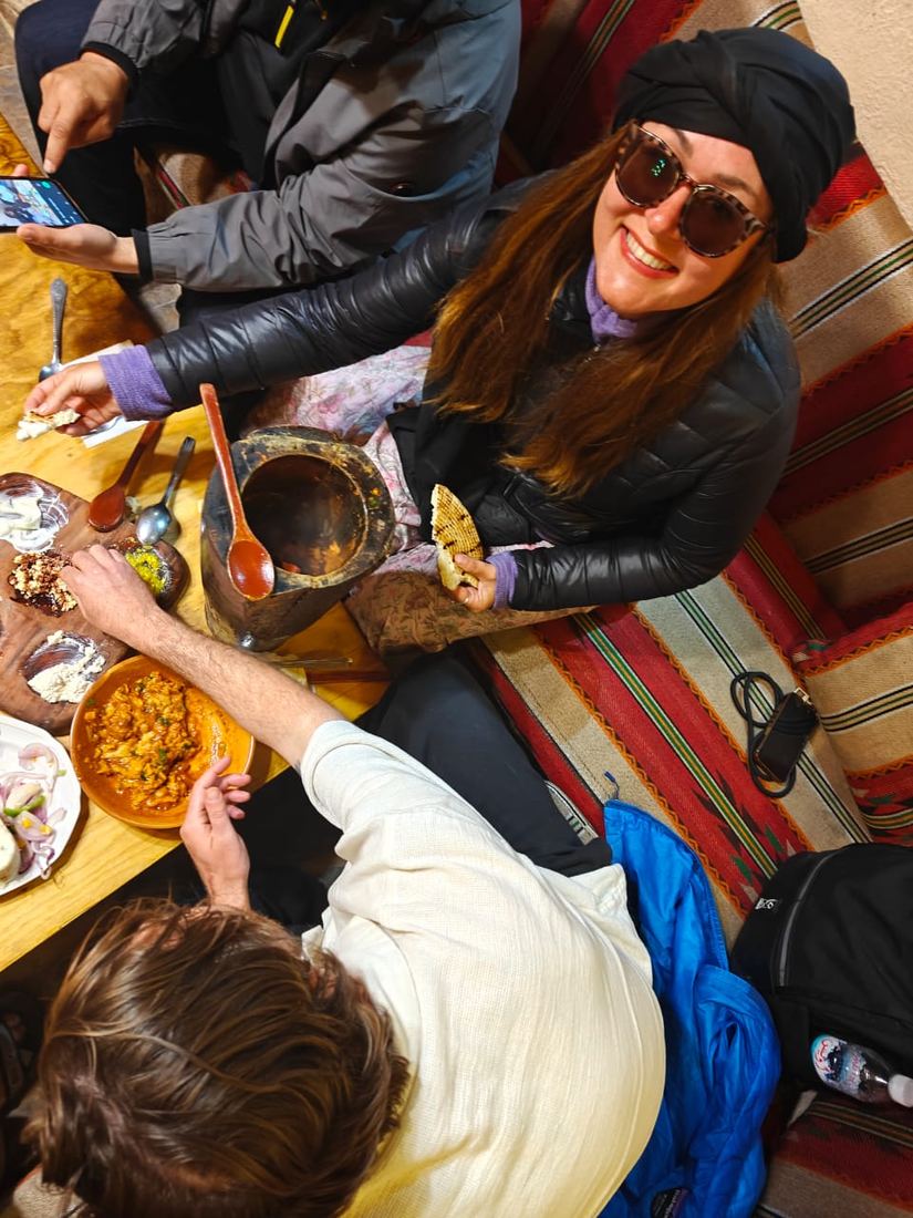 Travellers eating from shared bowls around a low table, seen from above