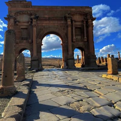 The Arch of Trajan seen from the paved main street of Timgad, its flagstones still rutted by cart wheels