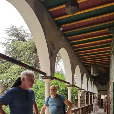 The arcaded upper gallery of the Ahmed Bey Palace in Constantine, under a painted red and green timber ceiling