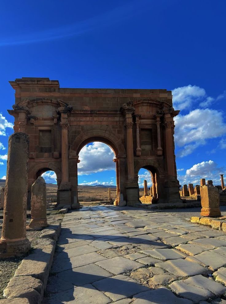 The triumphal Arch of Trajan standing among the Roman ruins of Timgad, Batna, Algeria